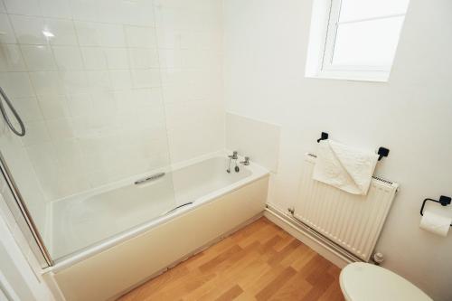 a bathroom with a white tub and a toilet at Cottages In Derbyshire, Oak Cottage in Hazelwood