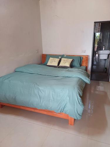 a bed with blue sheets and pillows in a room at Hill House in Mai Chau