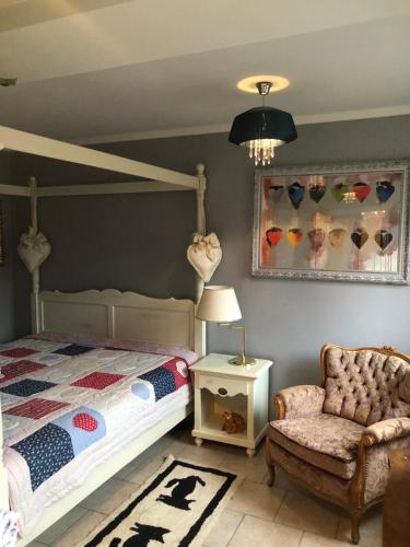a bedroom with a bed and a chair and a lamp at Little Cottage auf 2 Etagen in Raben Steinfeld
