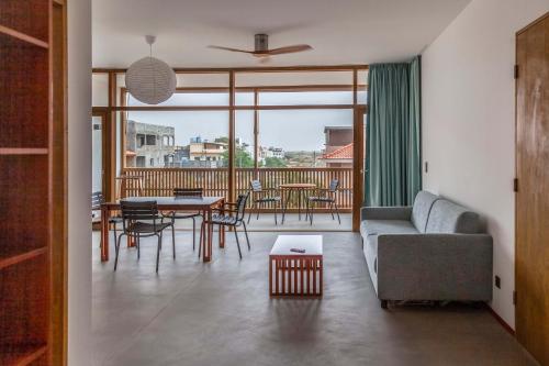 a living room with a couch and a table and chairs at King Fisher Village in Tarrafal