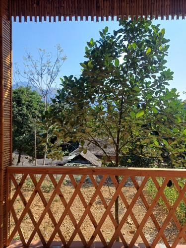 a wooden fence with a tree in the background at Hill House in Mai Chau