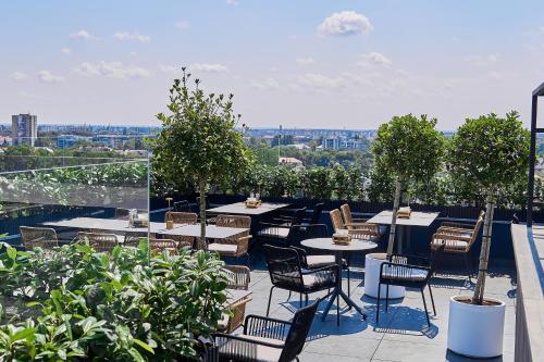 a patio with tables and chairs on a roof at WHITE HILLS HOTEL spa&sport in Uzhhorod