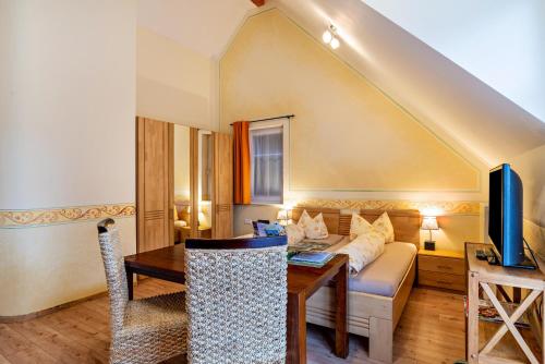 - un salon avec un canapé et une table dans l'établissement Schusterjunge Aparthotel A4, à Sasbachwalden