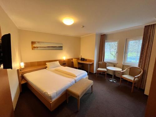 a hotel room with a bed and a table and chairs at Neugebauer-Garni, Johannisberg in Johannisberg