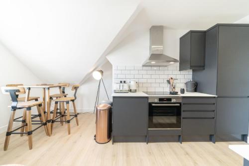 a kitchen with a stove and a table with chairs at 4 Ashbrook Windmill in Oxford