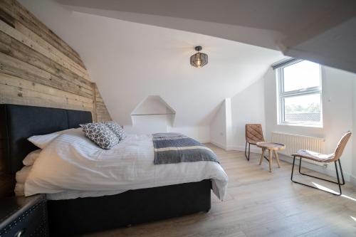 a bedroom with a large bed and a chair at 4 Ashbrook Windmill in Oxford