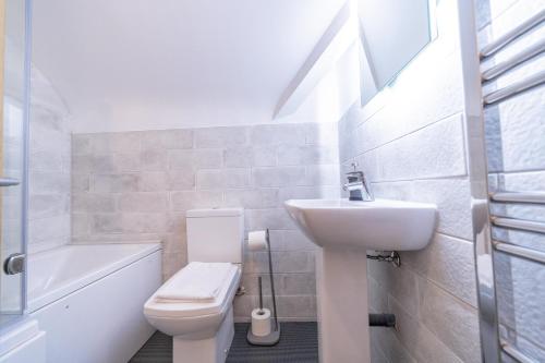 a white bathroom with a sink and a toilet at 4 Ashbrook Windmill in Oxford