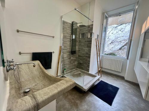 une salle de bain avec une douche en verre et un lavabo dans l'établissement Appartement sur la Corniche Kennedy face à la mer, à Marseille