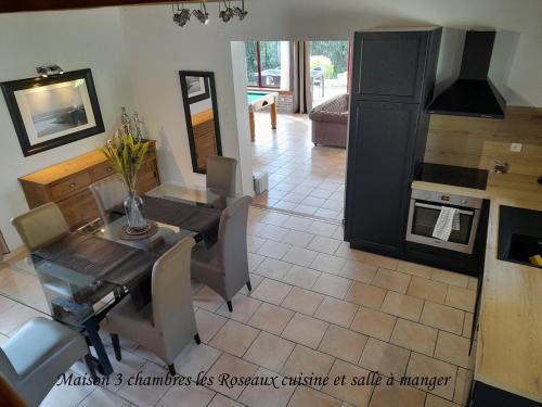 eine Küche und ein Esszimmer mit einem Tisch und Stühlen in der Unterkunft Domaine de l'Ermitage in Rue