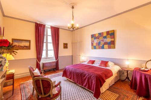 a bedroom with a bed and a table and chairs at Les Louteaux - Splendide Château du XVIII -Piscine- Parc de Lamas in Chézy