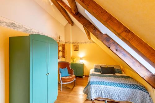 a attic bedroom with a bed and a staircase at Les Louteaux - Splendide Château du XVIII -Piscine- Parc de Lamas in Chézy
