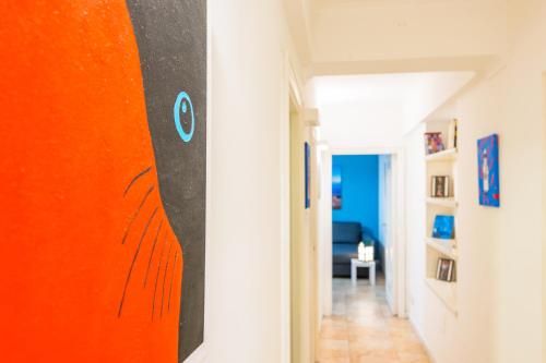 um corredor com uma pintura laranja na parede em Amedeo Comfort Apartment at Chiaia by Napoliapartments em Nápoles