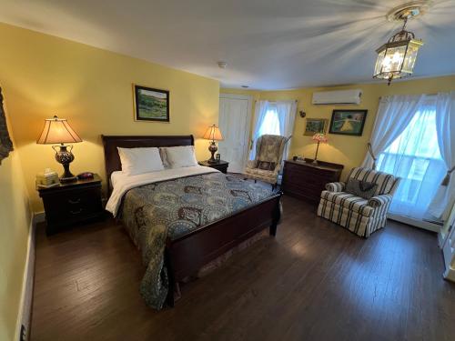 滑鐵盧的住宿－The Gridley Inn B&B，一间卧室配有一张大床和一把椅子
