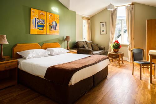 um quarto com uma cama grande e uma sala de estar em The Oystercatcher Lodge Guest House em Carlingford