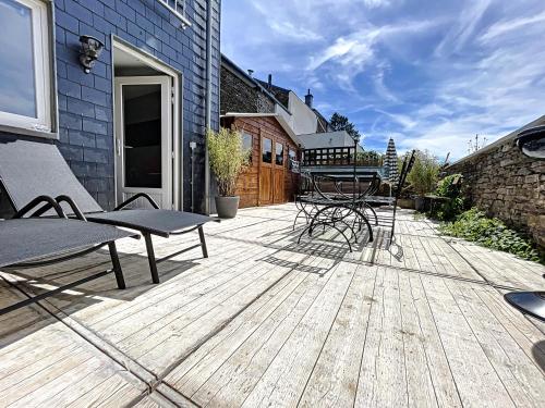 a wooden deck with chairs and a table on it at Le Doux Refuge de Bouillon in Corbion