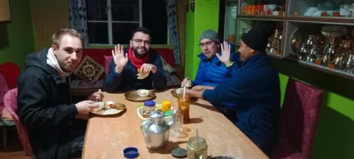 a group of men sitting at a table in a restaurant at Kabiraalaya Homestay in Darjeeling
