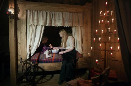 a woman sitting on a bed with a child at Wilderness Center / Óbyggðasetur Íslands in Óbyggðasetur