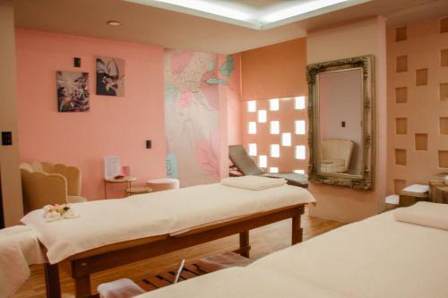 a therapy room with two beds and a mirror at Casa Rosa Hotel & Spa in San Cristóbal de Las Casas