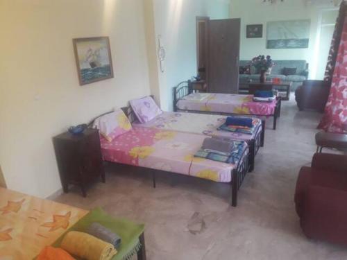 uma sala de estar com três camas num quarto em Hellas Palace ROOMS LOFT em Sparti