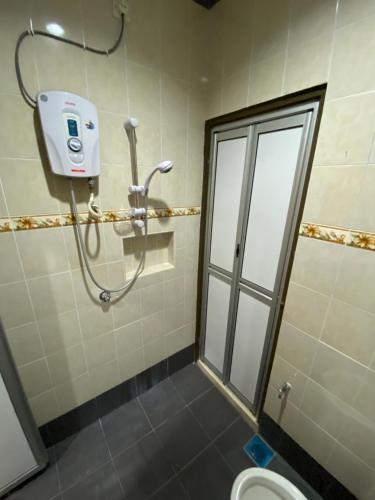 a bathroom with a shower stall and a toilet at Frosty Hills Homestay in Tanah Rata