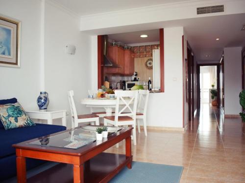 ein Wohnzimmer mit einem blauen Sofa und einem Tisch in der Unterkunft Luminoso apartamento de 3 dormitorios a pie de playa en Torremolinos in Torremolinos