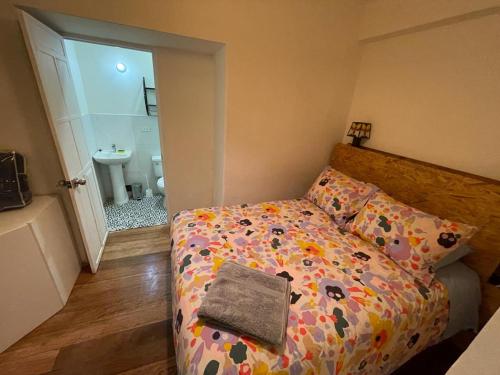a small bedroom with a bed and a bathroom at Illa B&B in Cusco