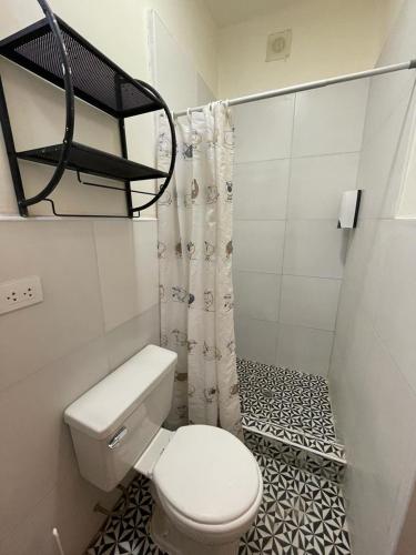 a bathroom with a toilet and a shower curtain at Illa B&B in Cusco