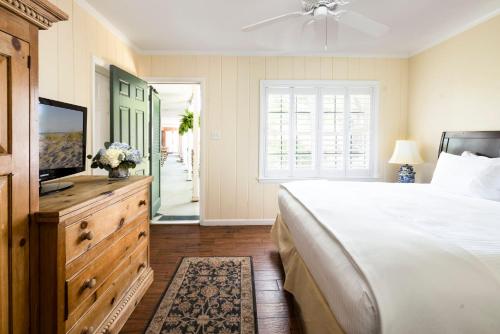 a bedroom with a bed and a flat screen tv at The Bellmoor Inn and Spa in Rehoboth Beach