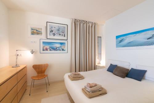 シッチェスにあるSitges Suites Bのベッドと机と椅子のある寝室