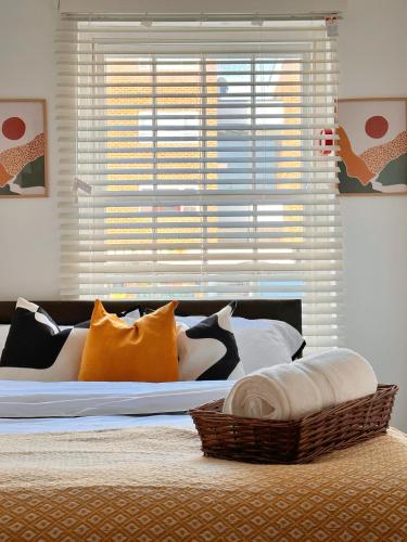 - un lit avec de nombreux oreillers et une fenêtre dans l'établissement Vibrant comfort (Suitable for Contractors,ShortStays and LongStays), à Portsmouth