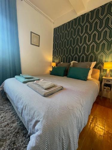 um quarto com uma grande cama branca e paredes verdes em Domaine La Belle Histoire - Gîte côté Parc em Besset