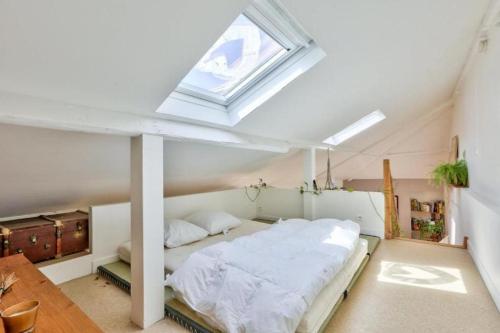 une chambre avec un grand lit avec une fenêtre dans l'établissement calme et verdure à Paris, à Paris