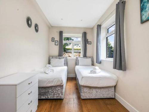 sypialnia z 2 łóżkami, biurkiem i oknem w obiekcie Pass the Keys Ealing Queen of the Suburbs 2BD Apartment w Londynie