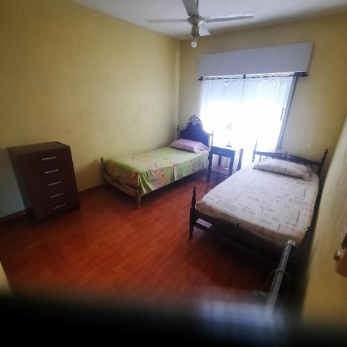 um quarto com 2 camas e uma cómoda e uma janela em El sueño de papá em Santa María