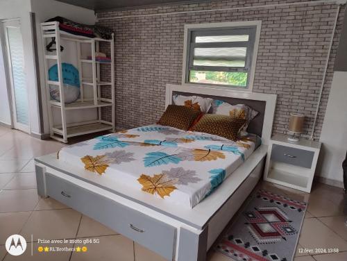 塔那那利佛的住宿－Maison familiale，卧室内的一张床位,卧室设有砖墙