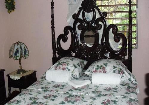 1 cama con colcha y almohadas de flores y ventana en Kingston Airport bed and breakfast en Kingston