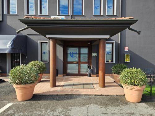 two potted plants sitting in front of a building at Hotel Euro in Castegnato