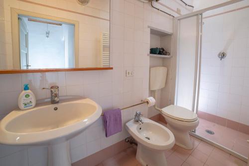 Baño blanco con lavabo y aseo en Holiday Home La Pace, en Pescaglia