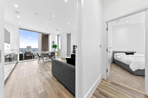 a bedroom with a bed and a living room at Battersea Penthouse Sleep 9 WH in London