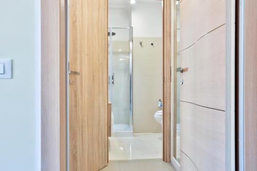 a bathroom with a shower with a glass door at Sebeto Apartments with Parking & Netflix in Naples