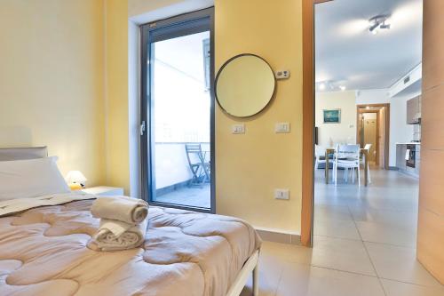 a bedroom with a bed with a mirror on the wall at Sebeto Apartments with Parking & Netflix in Naples