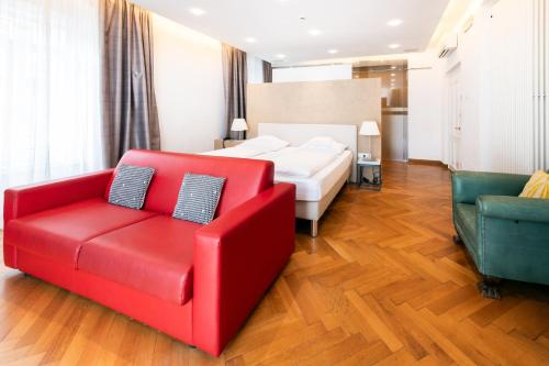 a bedroom with a red couch and a bed at Hotel Aurora in Merano