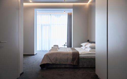 a bedroom with a bed and a large window at WHITE HILLS HOTEL spa&sport in Uzhhorod