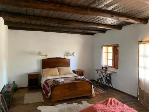 ein Schlafzimmer mit einem Bett und einer Holzdecke in der Unterkunft Estancia Santa Thelma in Gobernador Gregores