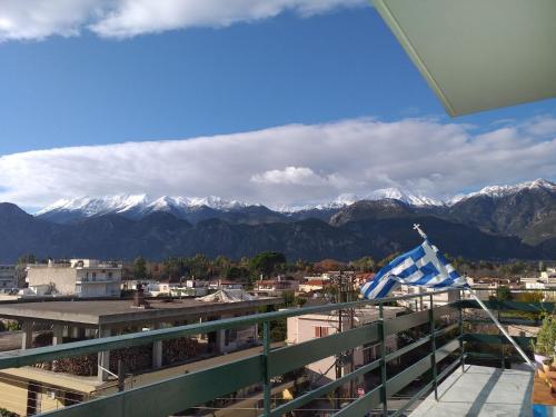 a view of mountains from a balcony with a flag at Hellas Palace ROOMS LOFT in Sparti