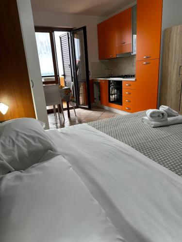 a bedroom with a white bed and a kitchen at Appartamenti Scilla Paese Albergo in Scilla