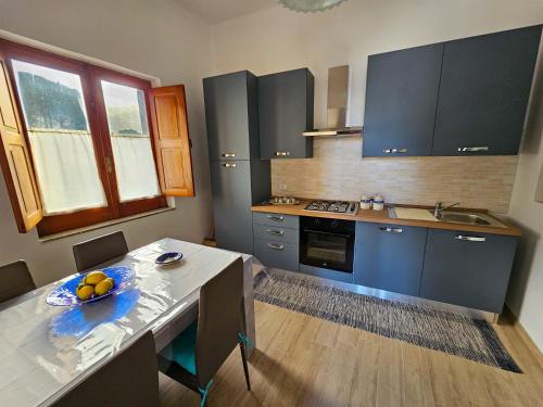 a kitchen with a table with a bowl of fruit on it at Case vacanza La Palmas nel centro di Malfa in Malfa