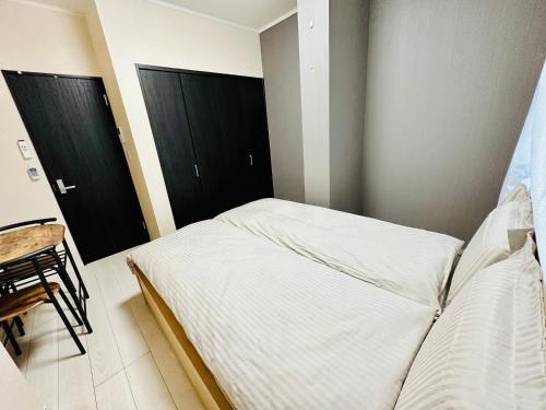 a bedroom with a bed and two black doors at Yokohama Paradise202 in Yokohama
