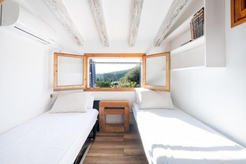 una stanza con due letti in una casetta di Villa Carrasca l Sea View l Pool l BBQ l ChillOut by Turyhost ad Arenys de Munt