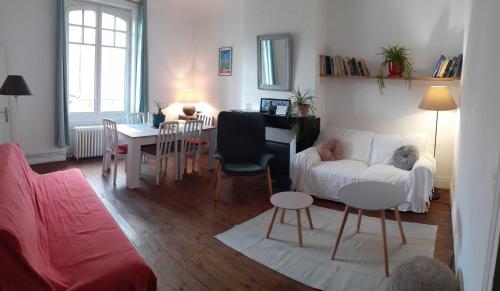 un salon avec un canapé blanc et une table dans l'établissement Grand 3 pieces en centre-ville, à Mont-de-Marsan